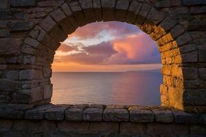 a view of the sea through an archway photo