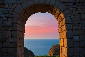 a view of the sea through an archway photo