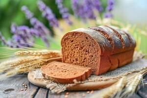 Rye cutted bread and ears of wheat on a wooden nature background. photo