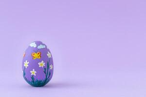 Painted Easter egg on purple background photo