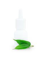 Spray bottle of medicine with green leaves of tea tree isolated on white photo