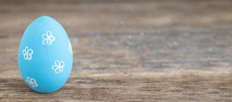 One blue painted Easter egg on wooden background photo