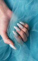 hembra manos con azul uña diseño. azul uña polaco manicura. foto