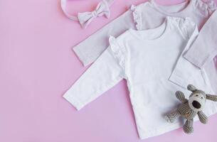 Set of baby bodysuits, pants, socks and knitted toy photo