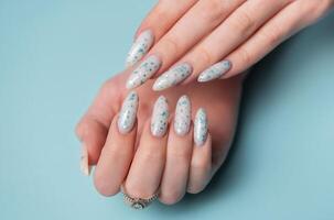Female hands with blue nail design. Blue nail polish manicure. photo