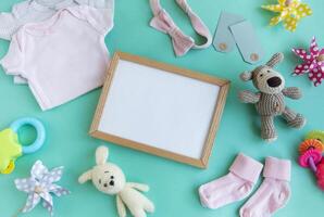 Baby garment and accessories and empty frame mockup. photo