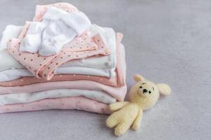 Stack of Baby bodysuits on a grey background. photo