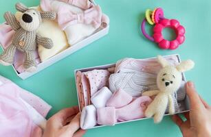 Women's hands collect children's clothes into boxes. photo