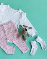 Set of baby bodysuits, pants, socks and knitted toy photo