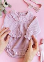 Pink bodysuit with toy knitted dog, socks and headband. photo