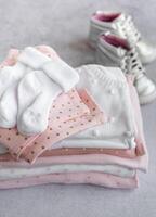 Stack of Baby bodysuits on a grey background. photo