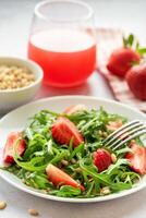 Fresh Strawberry Arugula Salad With Pine Nuts Served on a Bright Day photo