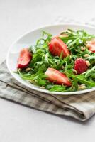 Fresh Strawberry Arugula Salad With Pine Nuts Served on a Bright Day photo