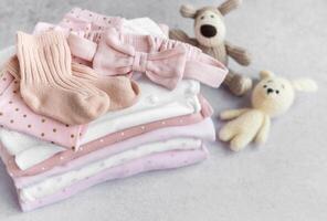 Stack of Baby bodysuits on a grey background. photo