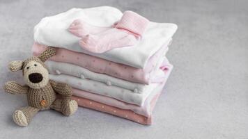 Stack of Baby bodysuits on a grey background. photo