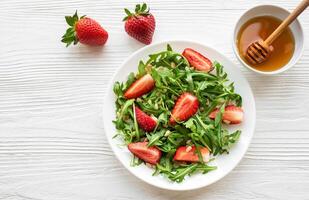 Fresh Strawberry Arugula Salad With Pine Nuts Served on a Bright Day photo