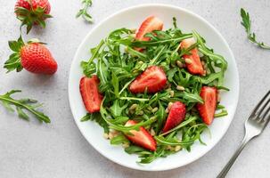 Fresh Strawberry Arugula Salad With Pine Nuts Served on a Bright Day photo