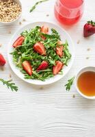 Fresh Strawberry Arugula Salad With Pine Nuts Served on a Bright Day photo