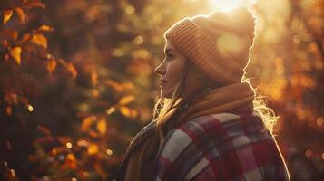 Autumnal Solitude Serene Woman Enveloped in Plaid Blanket Basks in Suns Embrace Among Fiery Forest Hues photo