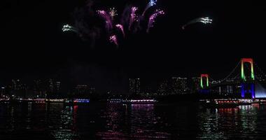 ein Nacht Feuerwerk in der Nähe von Regenbogen Brücke beim das städtisch Stadt im Tokyo breit Schuss video