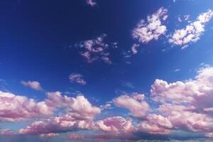 rosado cirro y cúmulo marcha atrás en un azul cielo antecedentes en un soleado verano día en bueno clima foto