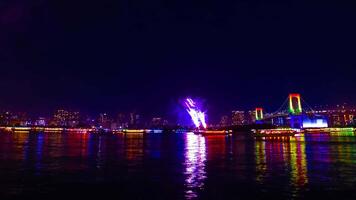 een nacht timelapse van vuurwerk in de buurt regenboog brug Bij de stedelijk stad in tokyo zoom video