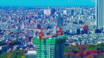 A timelapse of moving cranes at top of the building in Tokyo high angle long shot tilt video