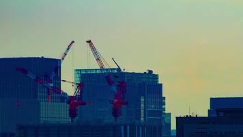 A timelapse of moving cranes at top of the building in Tokyo long shot video