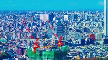 ein Zeitraffer von ziehen um Kräne beim oben von das Gebäude im Tokyo hoch Winkel lange Schuss Schwenken video