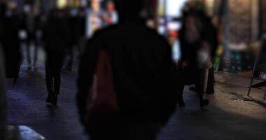 a piedi persone a il attraversamento nel Shinjuku tokyo piovoso giorno a notte video