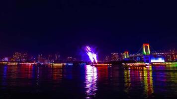 en natt Timelapse av fyrverkeri nära regnbåge bro på de urban stad i tokyo panorering video