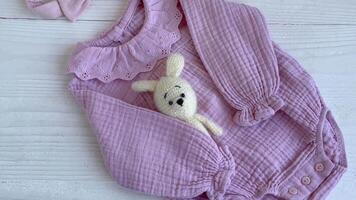 Pink bodysuit with toy knitted toy, socks and headband. video