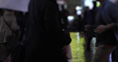 Walking people at the crossing in Shinjuku Tokyo rainy day at night video