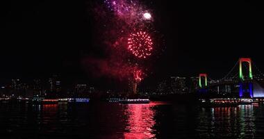 une nuit feux d'artifice près arc en ciel pont à le Urbain ville dans tokyo large coup video