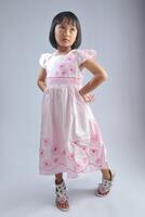 un indonesio pequeño niña vistiendo de moda vestir con modelado pose. foto
