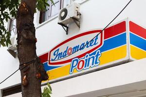 a signboard of indomaret point. place for people to relax and drink coffee. surabaya, indonesia - 21 february 2024 photo