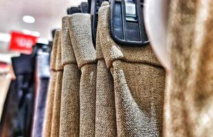 Rows of trousers in a clothing store hanging neatly on hangers. photo