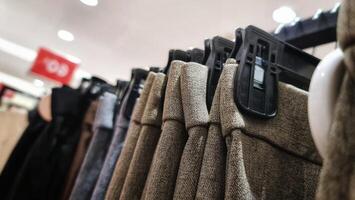 Rows of trousers in a clothing store hanging neatly on hangers. photo