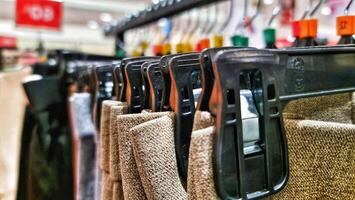 Rows of trousers in a clothing store hanging neatly on hangers. photo