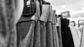 Rows of trousers in a clothing store hanging neatly on hangers. photo