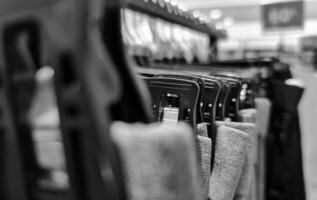 Rows of trousers in a clothing store hanging neatly on hangers. photo