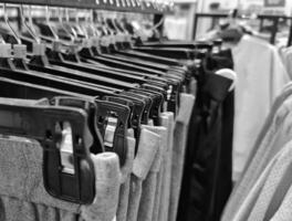 Rows of trousers in a clothing store hanging neatly on hangers. photo