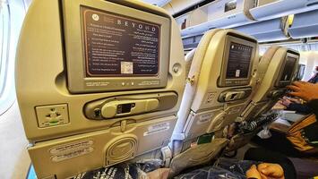 Medina, Saudi Arabia on March 3, 2024. Umrah pilgrims board a Saudi Arabia Airlines plane to return to their home country, Indonesia. Plane to Jakarta. Passengers look for their seats. photo