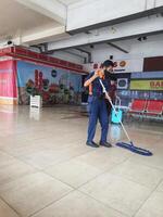 Jacarta, Indonesia en julio 7 7 2022. un limpiador a halim perdanakusuma aeropuerto. esta oficial es limpieza el aeropuerto piso entonces ese eso es limpiar y no resbaladizo. foto