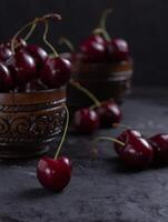 Organic juicy cherry in a bowl on dark background. Close-up photo, low key, selective focus photo