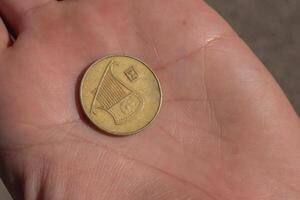 moderno israelí moneda en el mano. 0,5 sheqel foto
