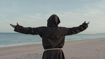 religioso monje con reza hacia el mar con abierto brazos foto