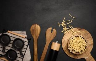 Raw wheat noodles in wooden bowl, top view photo