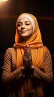 European woman wearing scarf is praying and smiling on brown background photo