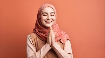 European woman wearing scarf is praying and smiling on red background photo